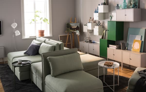 A living room is styled with modular sofas and lots of wall storage.