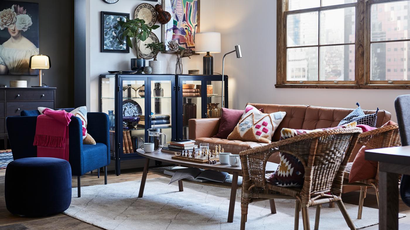 A living room with armchairs and a LANDSKRONA sofa around a coffee table, with a display cabinet to the left of the sofa.
