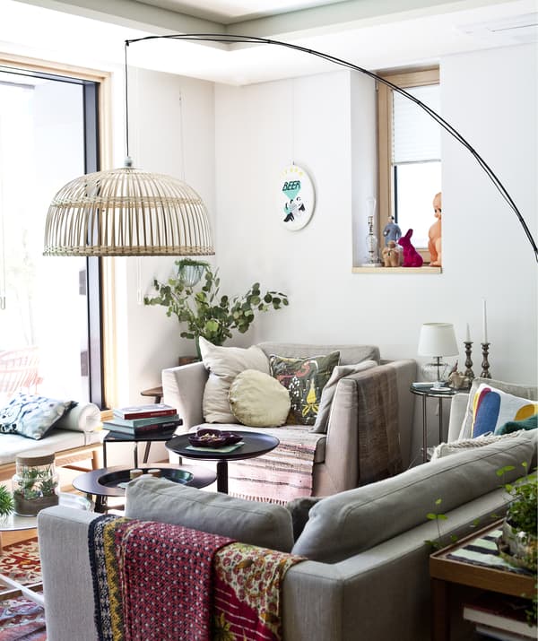 A living room with sofa, armchair and large floor lamp.
