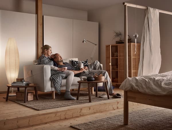 A man and a woman relaxing on a sofa.