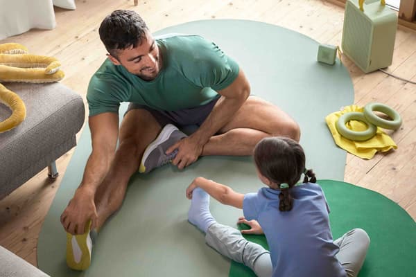 A man and his daughter stretching their legs on DAJLIEN sport mat. 