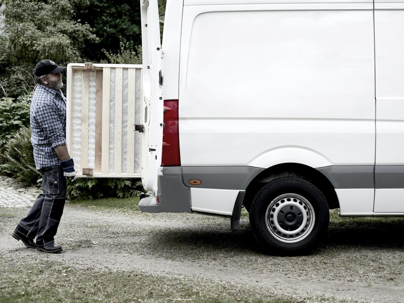 A man loading a white hire van from IKEA.