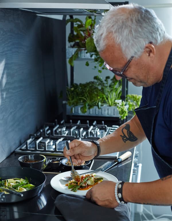 A man plates a dish of salad.
