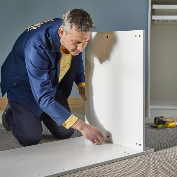 A man putting together some IKEA furniture.