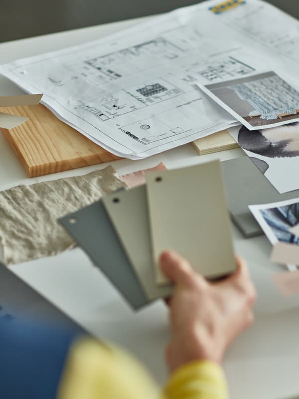 A man with a beard and glasses carrying a folder containing IKEA documents.
