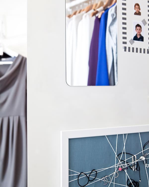 A mirror and pinboard on a white wall.