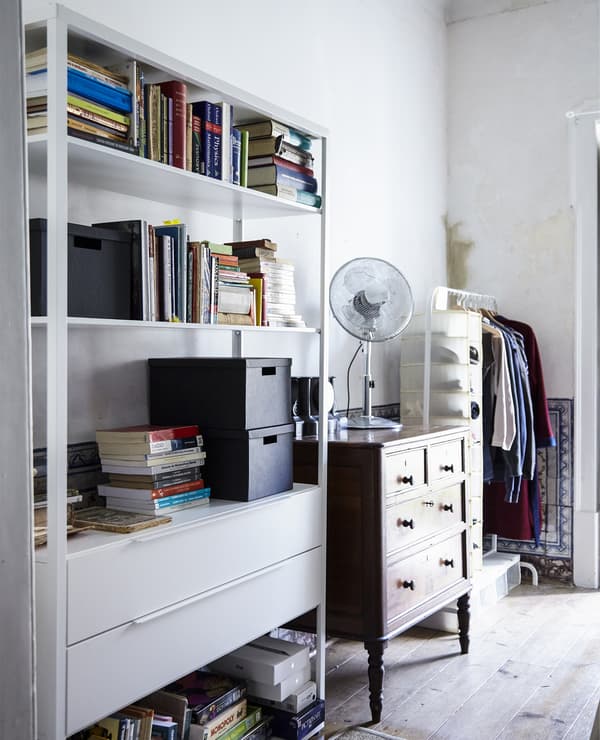 A mix of traditional and modern furniture pieces provide open and closed storage in this bedroom.