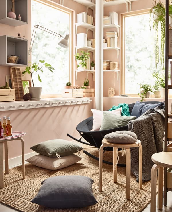  A mixed seating area created on a LOHALS flatwoven jute rug in a pink living room.