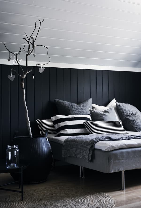 A monochrome bed with cushions.