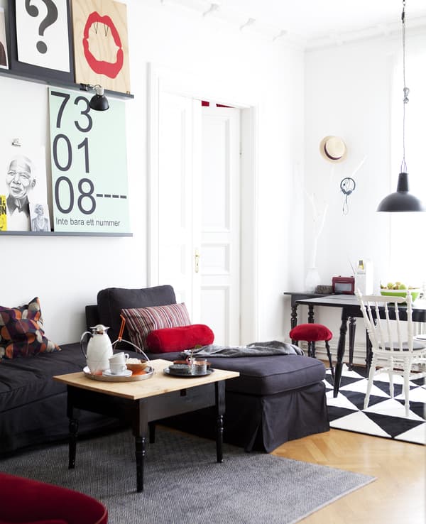 A monochrome room with red accessories.