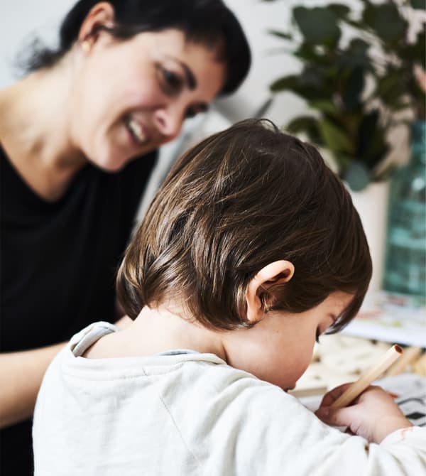 A mother and child writing labels for plants.
