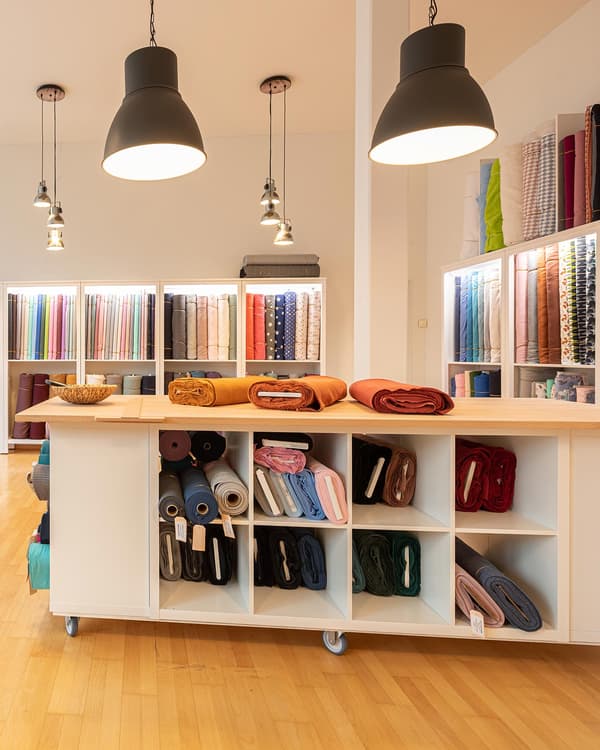 A movable cutting table for fabric on castors in a fabric shop.