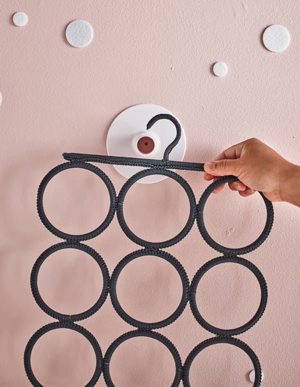 A multi-use hanger that will become an advent calendar being hung onto a wall holder.