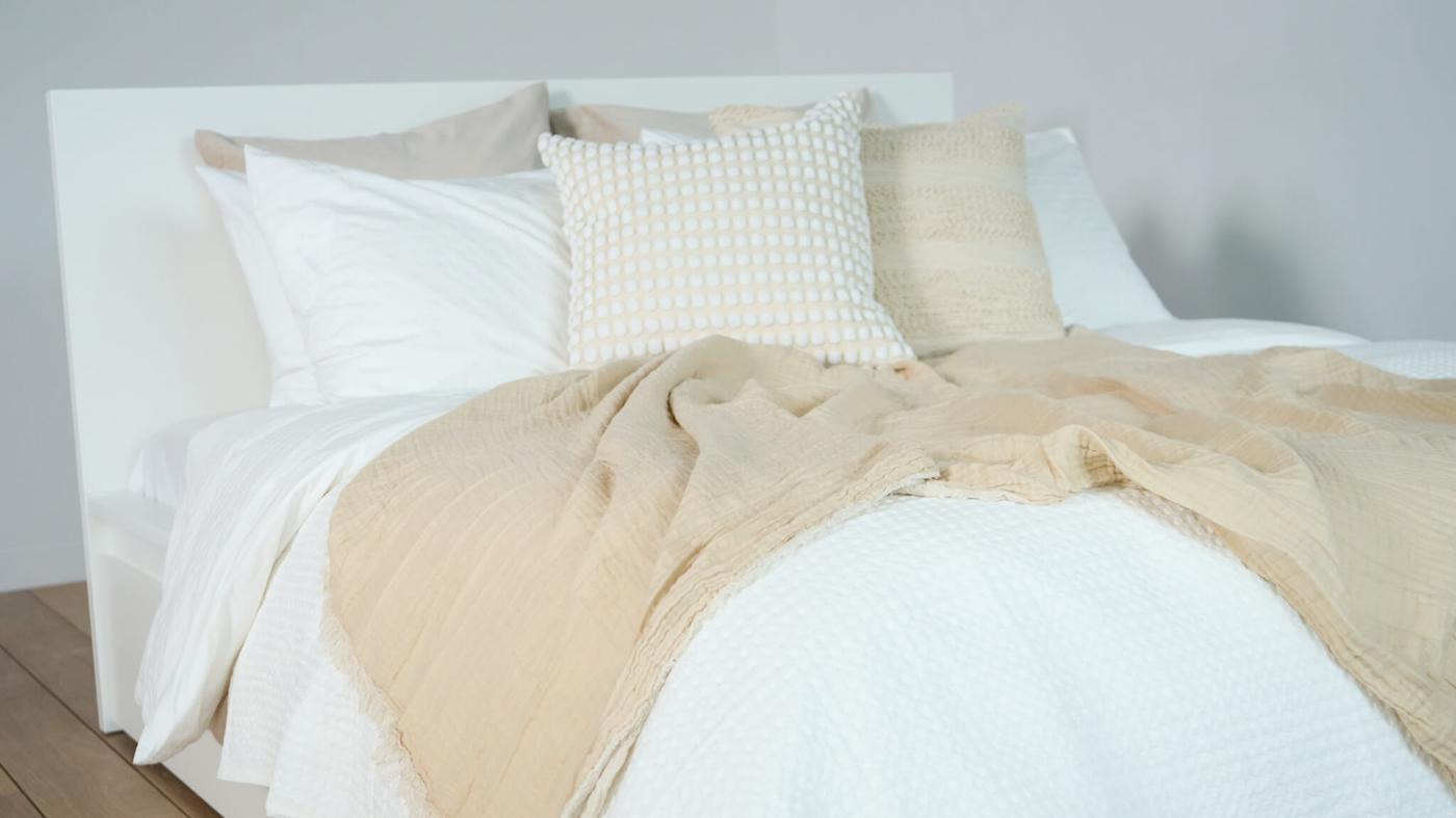 A neatly made bed with neutral tones.