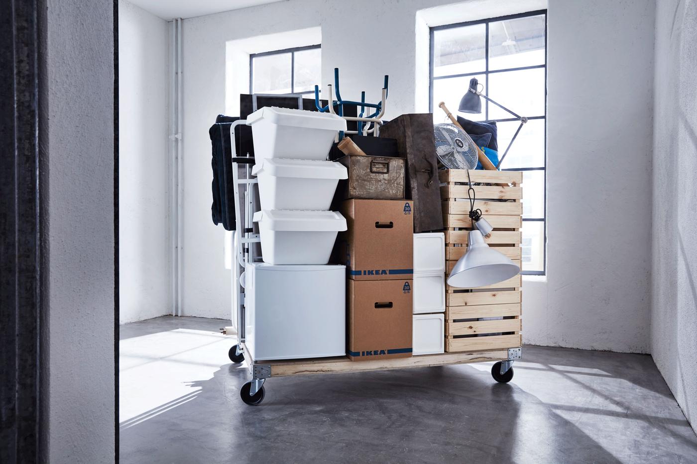 A packed apartment and moving boxes on a wagon.