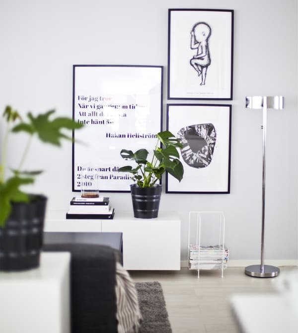 A pale grey wall decorated with black-and-white pictures.