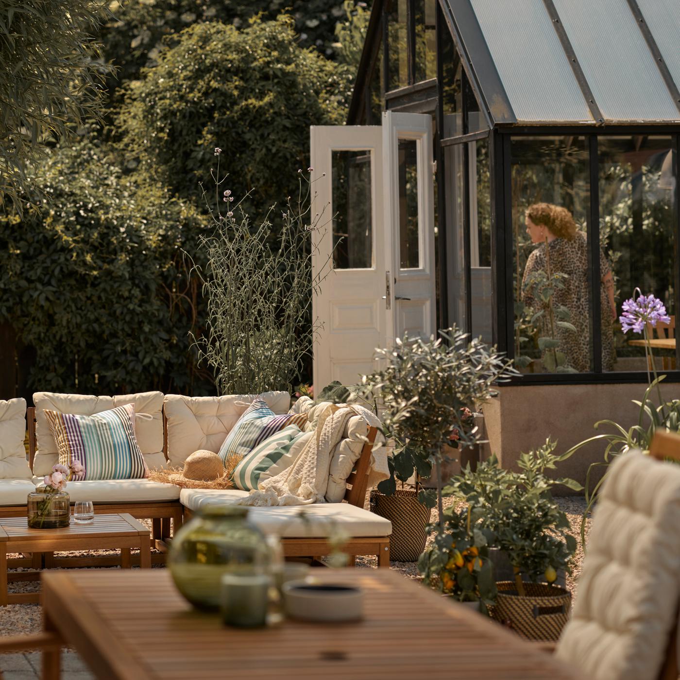 A patio with a light brown outdoor modular sofa with cushions, plus a light brown outdoor table with a reclining chair.
