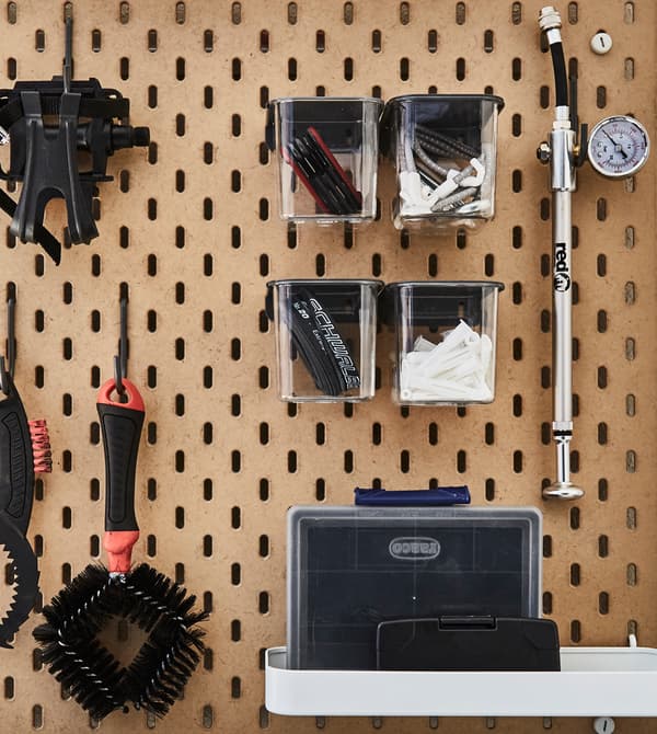A peg board on the wall stores tools for outdoor gear.
