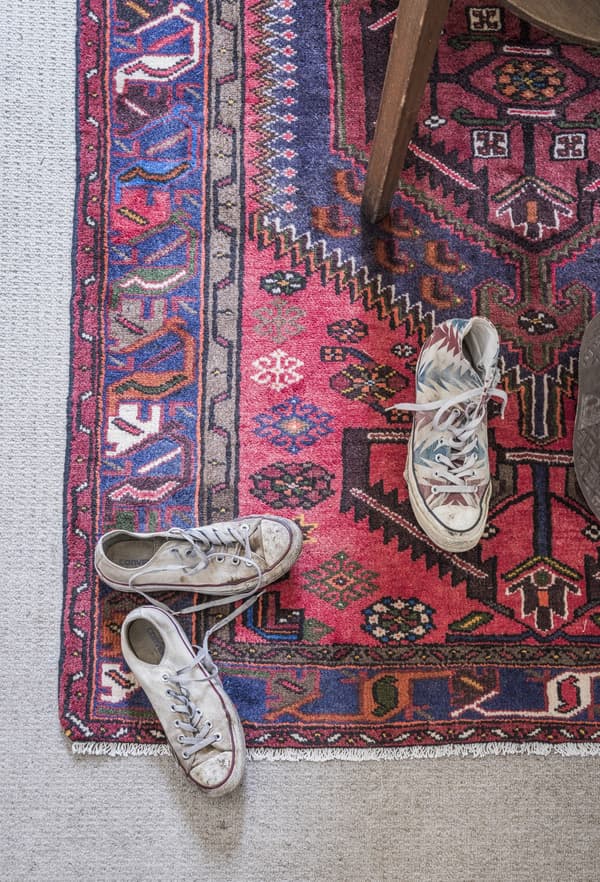 A Persian floor rug with trainers.