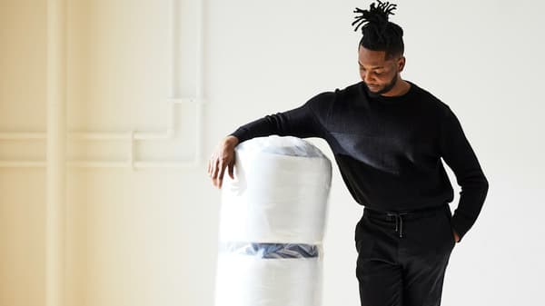 a person leading on a roll-packed IKEA mattress