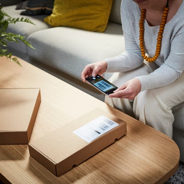 A person scanning an IKEA product in a box.