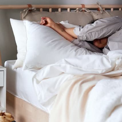 A person sleeping in her bed peacefully. 