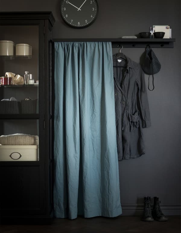 A picture ledge is a DIY coat rack shelf with knobs attached and a fabric in front to hide clutter.