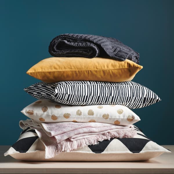A pile of patterned cushions and throws.