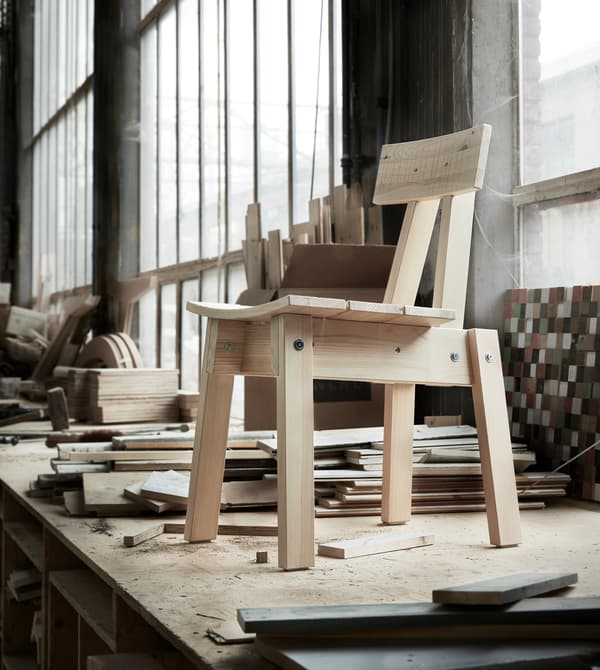 A pine chair standing on a work bench.