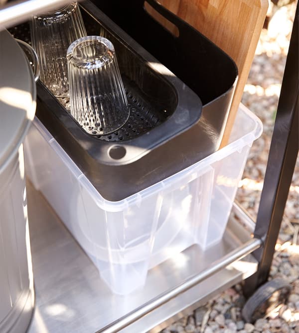  A plastic container stores items needed to wash-up in an outdoor kitchen.