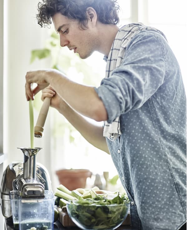 A portrait of a man preparing vegetables.