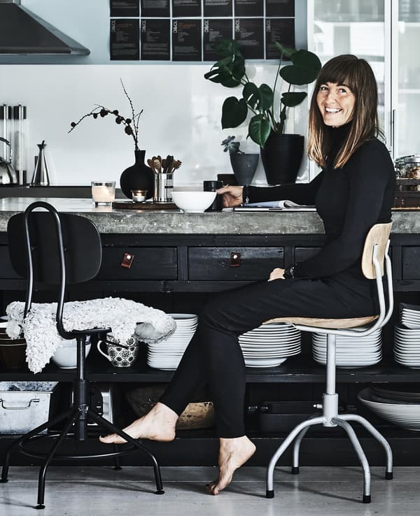 A portrait of Anita drinking tea in her kitchen.