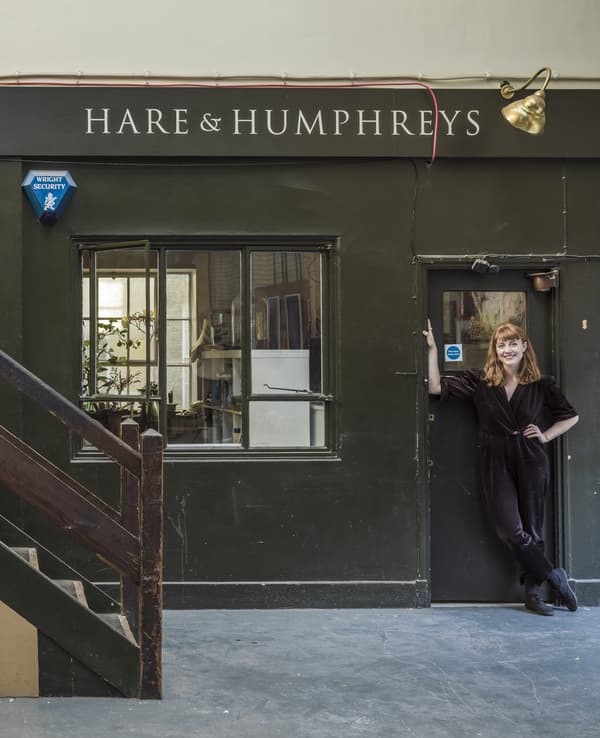 A portrait of Hannah standing outside her front door.