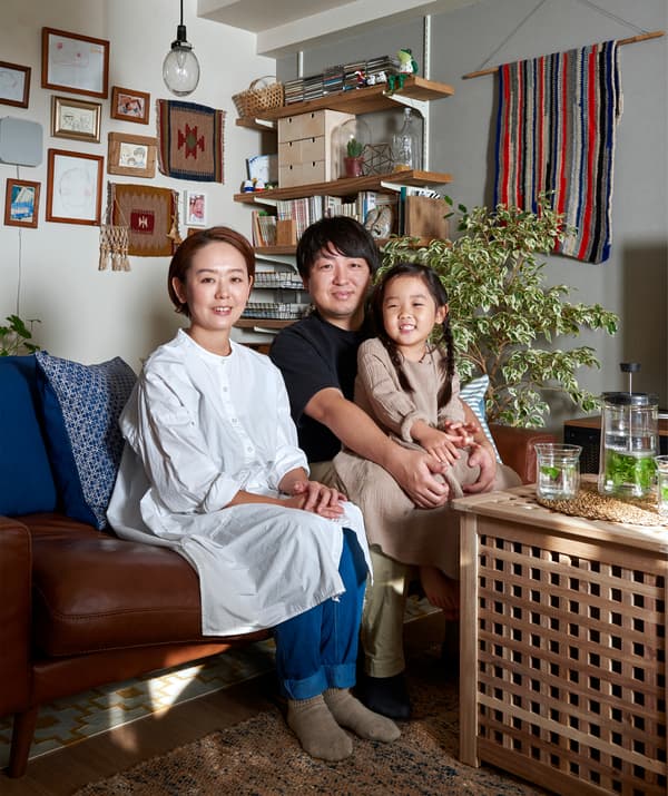 A portrait of Mieko, Kenta and their daughter sitting on a sofa.