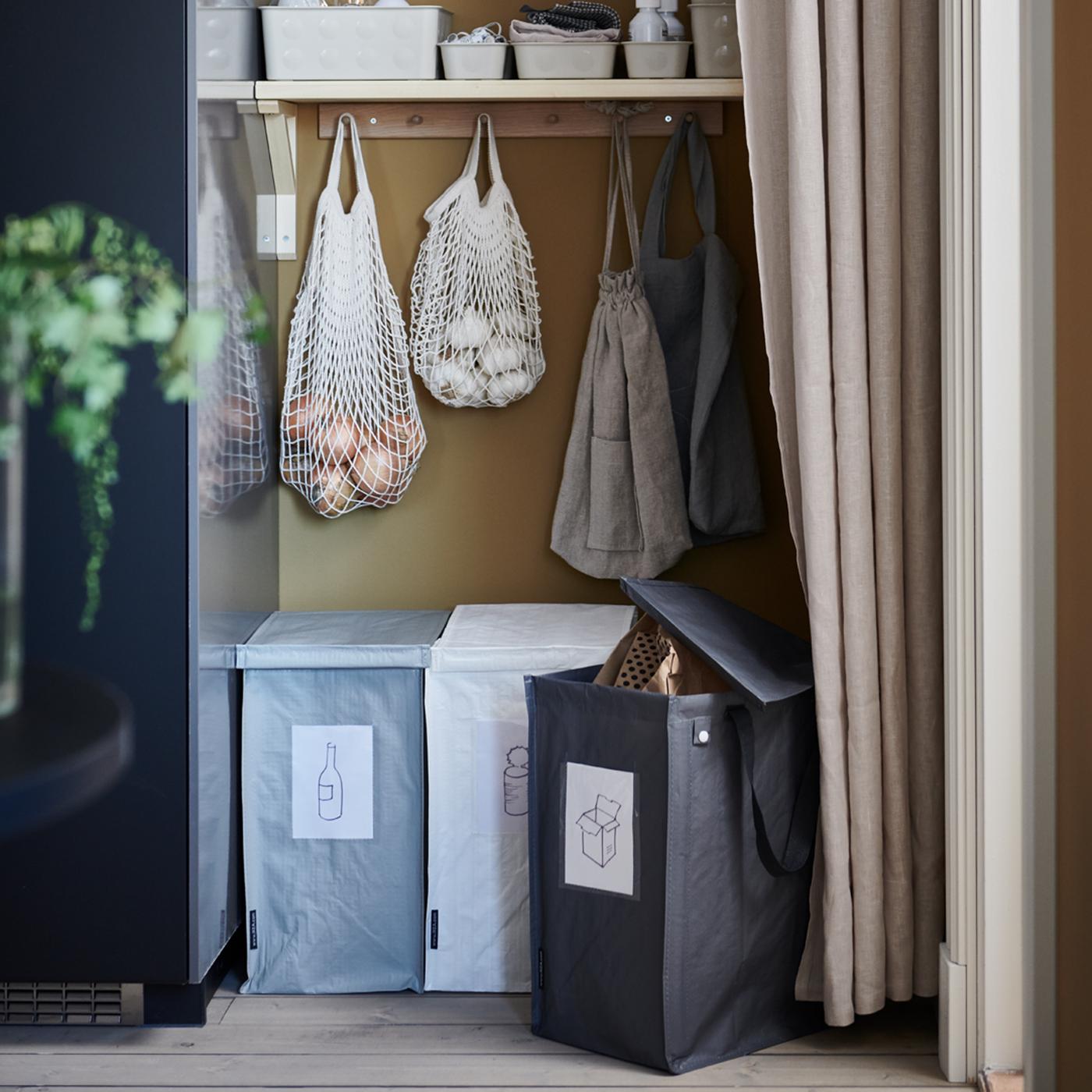 A recycling station with three DIMPA waste-sorting bags, shelves and KUNGSFORS net bags placed in a recess behind a curtain.