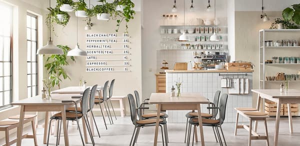 A Restaurant snapshot of table seating and board with a restaurant menu on the wall. 