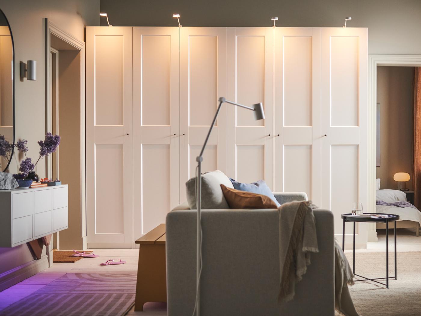 A room with a beige VIMLE 2-seat sofa-bed in the middle and two white PAX/GRIMO wardrobes along the back wall.