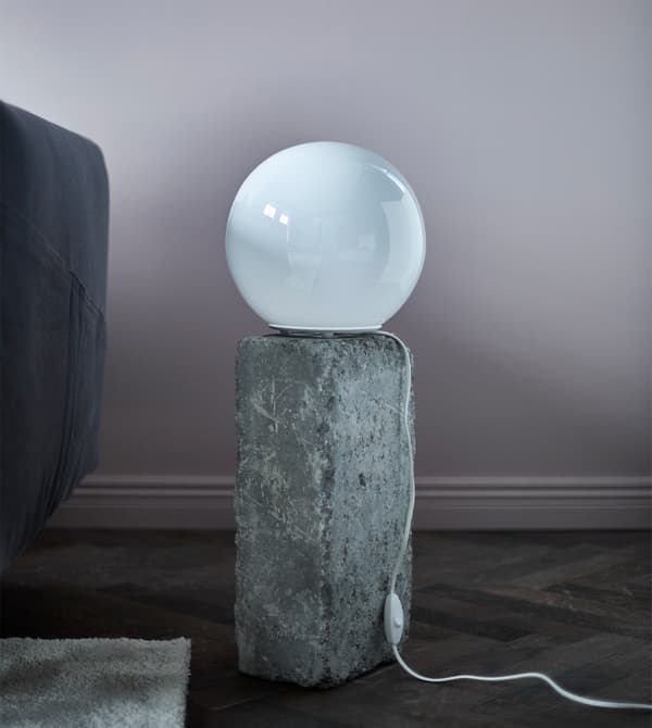 A round table lamp sitting on a rock.