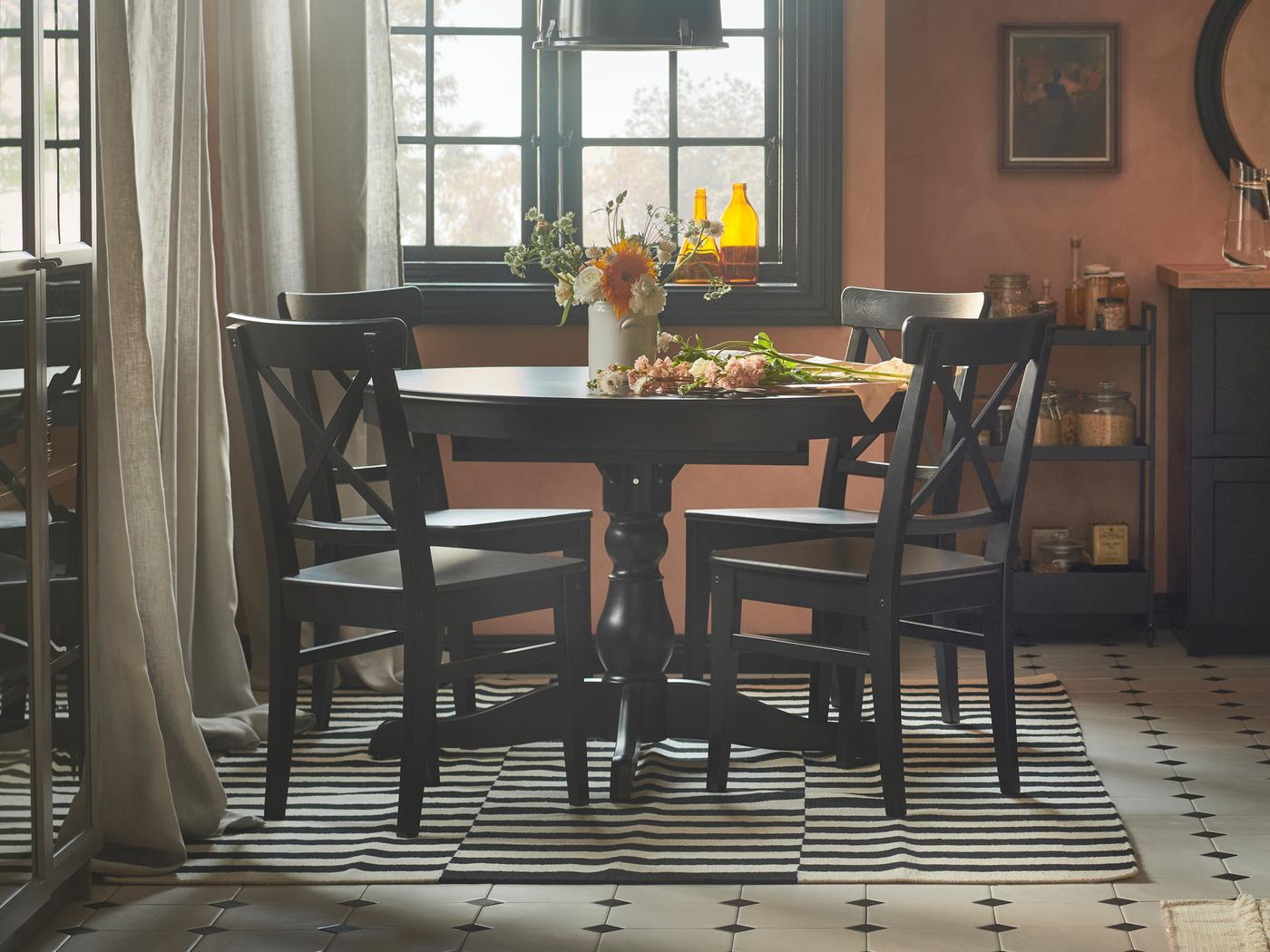 A rustic dining space with pink-coloured walls, an INGATORP extendable table and four INGOLF chairs.