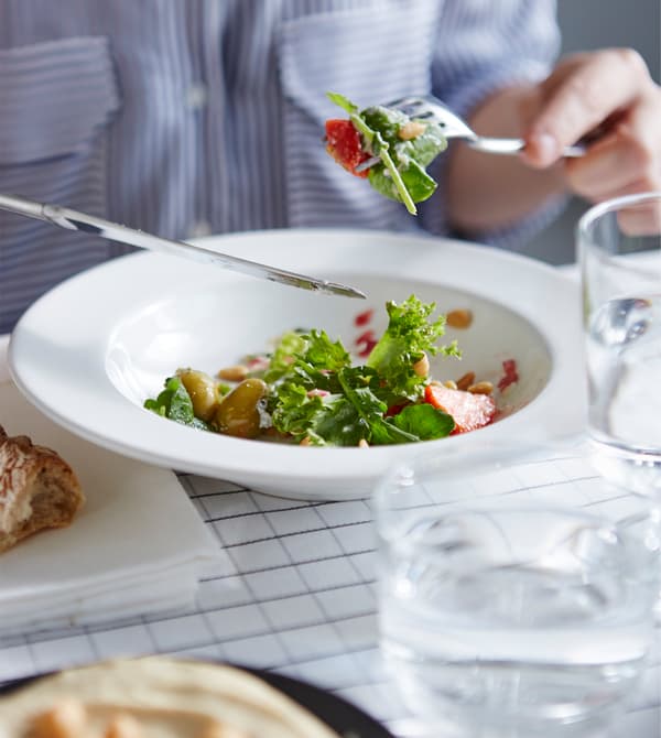 A salad is eaten at a dining table.