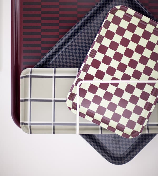A selection of patterned trays fixed to a white wall.