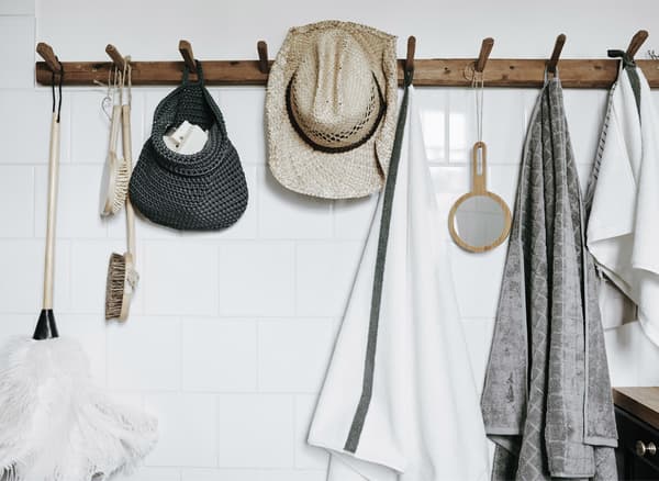 A set of wooden hooks mounted on a white wall to make bathroom essentials easy to reach.