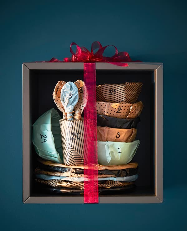A set of wrapped and numbered dinnerware is wrapped and displayed on a shelf.