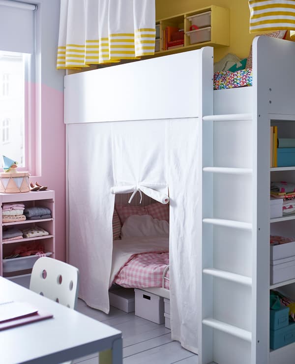 A shared kids’ room with a loft bed and an extendable bed in the space below, and a desk and chair.