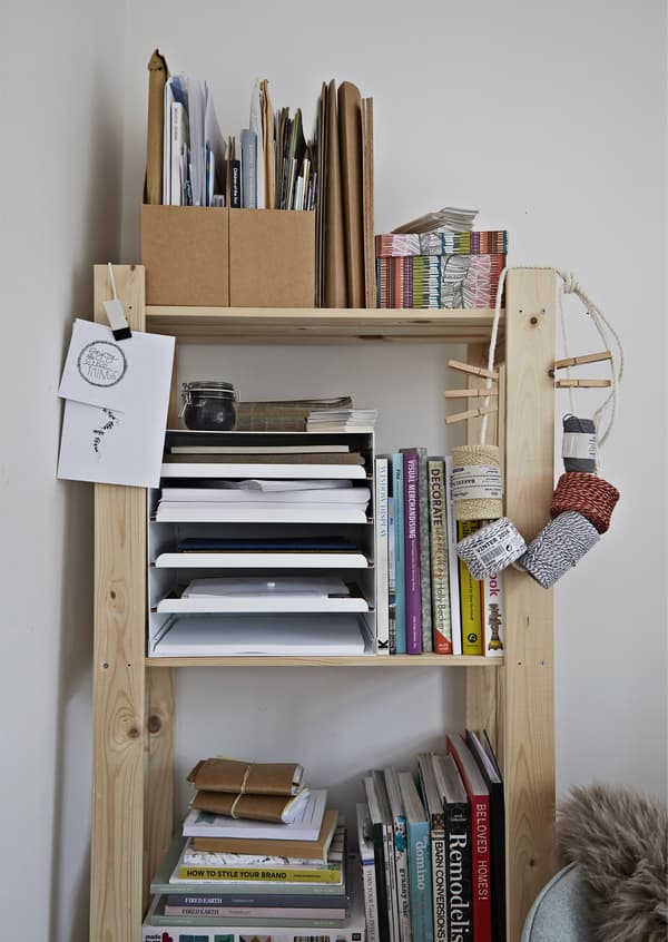 A shelving unit stacked with books and papers.