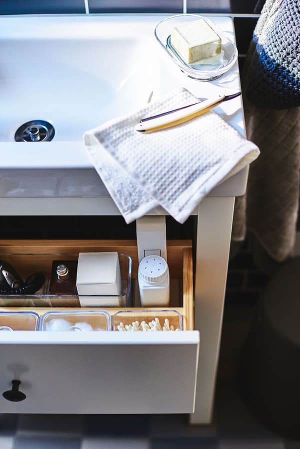 A sink with a bathroom drawer open underneath.