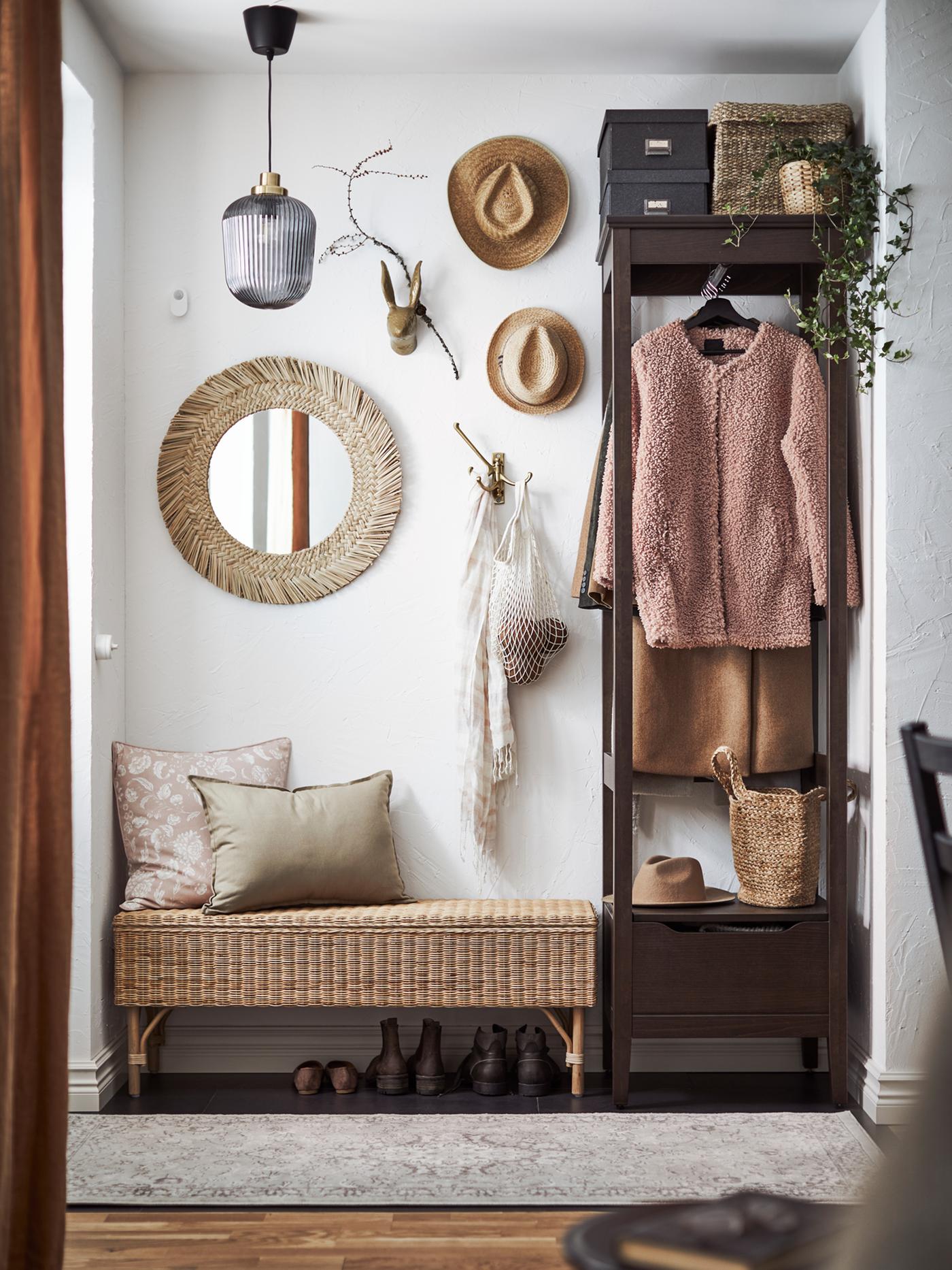 A small hallway containing an IDANÄS dark brown open wardrobe and a TOLKNING bench with storage with two cushions on top.
