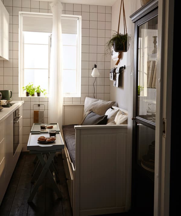 A small kitchen with a sofa bed and two tray tables.