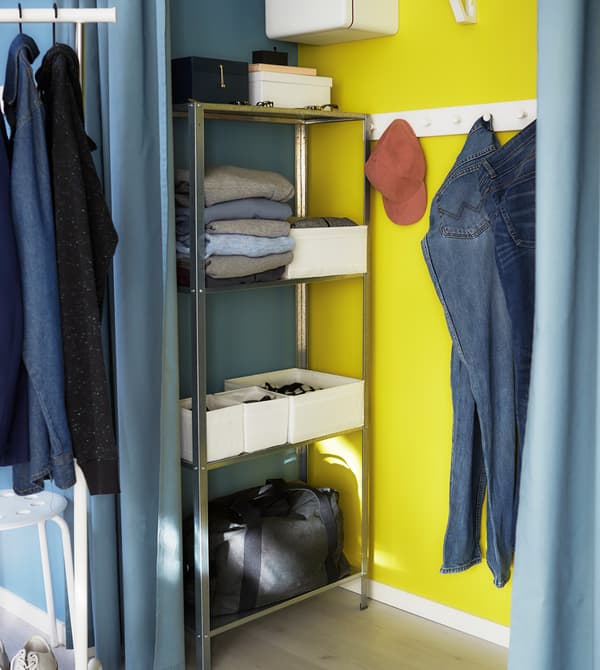 A small shelving unit and hooks help to keep a closet functional and organised.