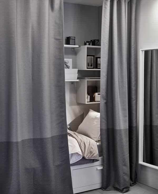 A small sleeping space gets extra privacy with curtains that work as a room divider. 